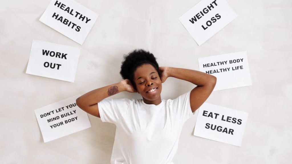 Smiling woman embracing positive lifestyle with healthy living messages around her.